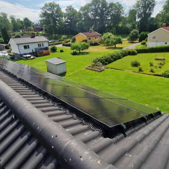 Översiktsbild av villa med solceller och trädgård