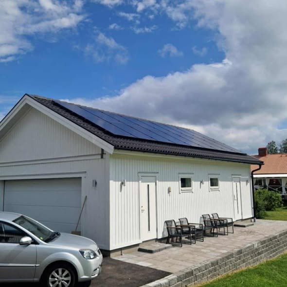 Vit villa med solceller på carport